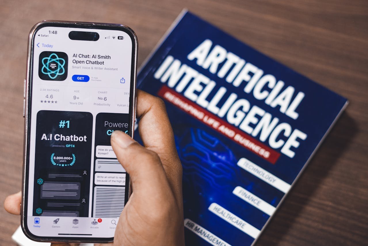AI chatbot app on a apple smartphone next to a book on artificial intelligence