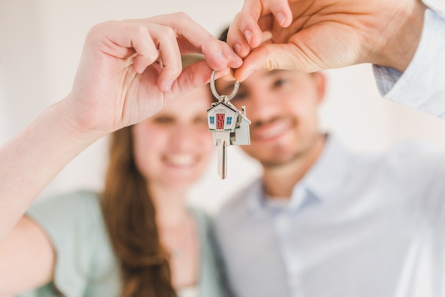 two people holding up a pair of keys